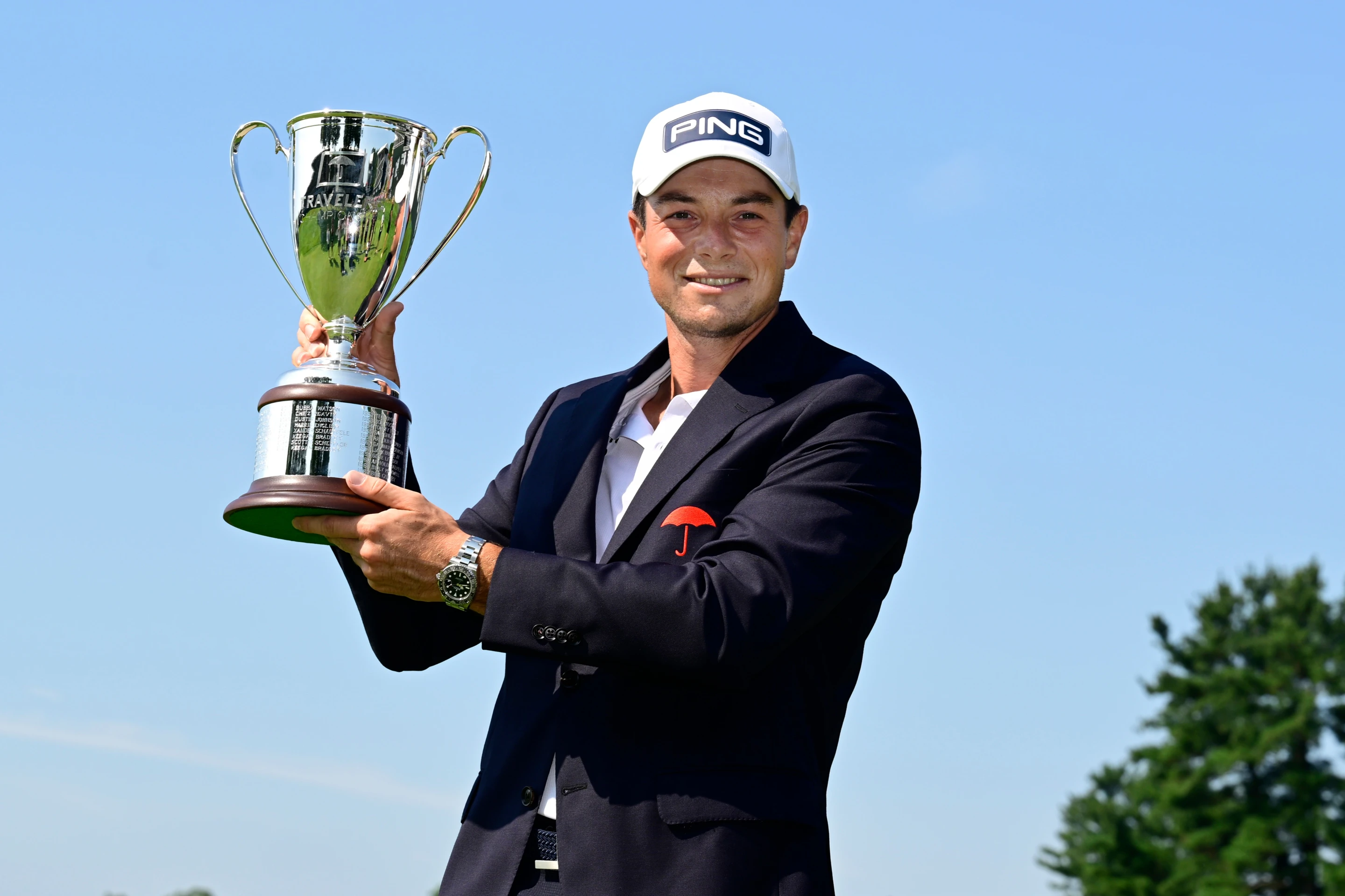 Viktor Hovland holding the Travelers Championship trophy