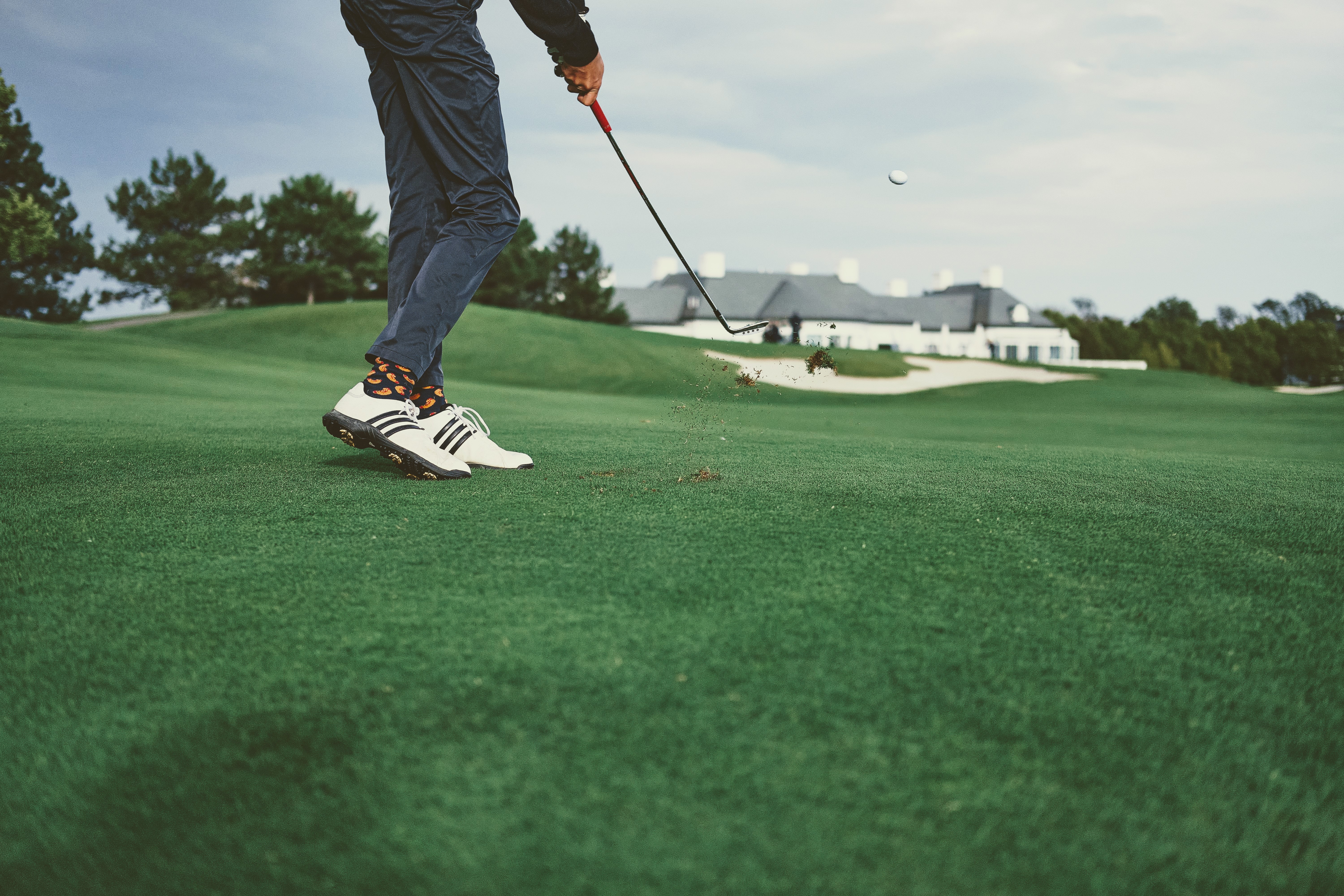 A golfer striking an iron shot on the fairway
